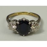 An 18ct gold, platinum, sapphire and diamond ring, the central sapphire flanked by two diamonds,