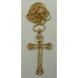 A 9ct gold cross pendant in an open work design, 5.6g, on an 18ct gold chain, 13.2g.