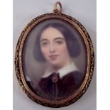 An early Victorian miniature of a young woman, painted on ivory, the mount having engraved verso