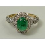 A gold, emerald and diamond ring, the central 1ct cabochon emerald surrounded by two rows of