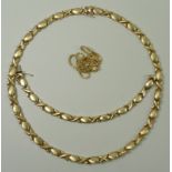 A 14ct gold necklace and bracelet suite of brushed gold lozenges between polished stylised crosses,
