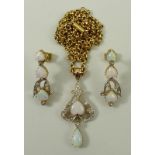 An opal and diamond suite comprising a pendant on chain and a pair of earrings, the pendant set