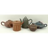 A group of five Chinese Yixing pottery teapots, each with inscribed character decoration, largest
