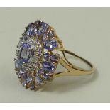 A tanzanite and diamond cluster ring, the pale lilac central tanzanite within a diamond set oval