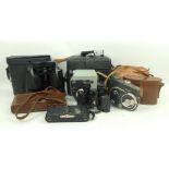 A collection of camera equipment comprising two Quartz cine cameras, a No 5 Ensign Carbine folding