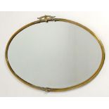 An Arts and Crafts brass oval mirror, circa 1900, with bevelled plate, 74 by 51cm.