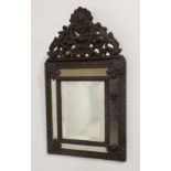 A 19th century copper framed cushion wall mirror, with sectional bevelled plates, 33 by 59cm.