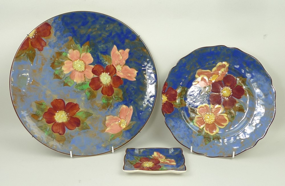 A Royal Doulton pottery charger decorated in the 'Wild Rose' pattern, 34cm diameter, together with