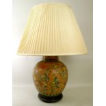 A 20th century Chinese ceramic table lamp of ovoid form, the rose orange ground decorated with