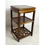 A 20th century Chinese hardwood two tier side table, with carved detail and sectional lower tier,