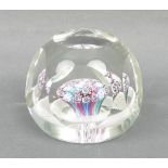 A faceted glass paperweight containing concentric millefiori canes within an opaque latticino ring,