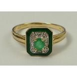 A 14ct gold and emerald ring, the central oval emerald set in a canted rectangular surround set