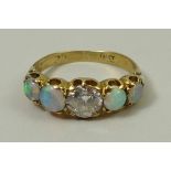 An 18ct gold, diamond and opal ring, the central diamond of approximately 0.75ct flanked by two