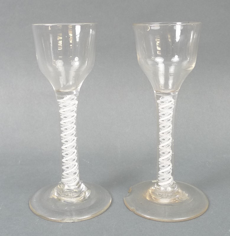 A pair of George III cordial glasses, circa 1780, the pan tops above a straight double opaque twist