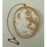 An oval shell cameo brooch depicting a classical lady in a chariot being crowned by a cherub, in a