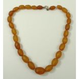 A faceted amber bead necklace, twenty seven beads, 19.4g, on a gold clasp.