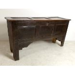 A 17th century oak coffer, the thee panel lid opening to reveal a candle box, a/f repairs,