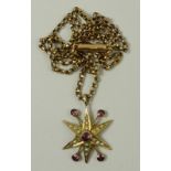 A 9ct gold, garnet and seed pearl star burst pendant on a 9ct gold kerb link chain, 5.7g.