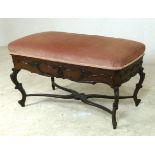 A duet piano stool, with applied carved decoration, lift seat upholstered with pink velour,