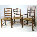 Two 19th century elm ladderback chairs and matching carver, with rush seats.