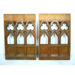 A pair of pine Gothic style panels, carved and pierced with trefoils above arches, 64 by 96 by 6cm.