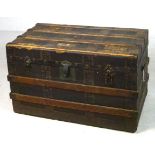 A Victorian travelling trunk with wooden straps, three front clasps and iron carrying handles,