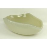 A Contemporary opaque glass bowl of oval form with an undulating rim, 37 by 29 by 13cm.
