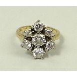 An 18ct gold and diamond seven stone ring of double triform design,