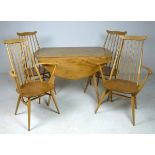 An Ercol drop leaf table and four stick back dining chairs with solid elm seats,