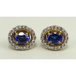 A pair of 14ct gold and tanzanite earrings of oval form in a surround of diamonds, tanzanites 1.