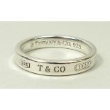 A Tiffany & Co silver band, engraved externally, size S, in a draw string bag.
