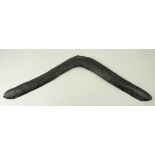 A 19th century Aboriginal boomerang with traces of original carved decoration, 54cm long.