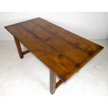 A fruitwood refectory kitchen table, three plank top with breadboard ends, on a trestle base,