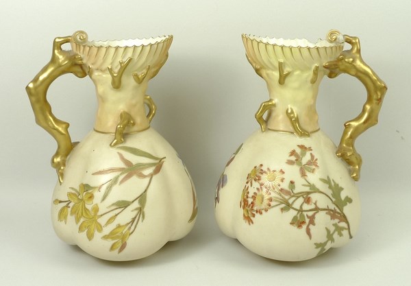 A pair of Royal Worcester blush ivory jugs, shape 1507, decorated with sprigs of spring flowers,