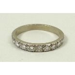 A white metal and diamond half hoop eternity ring of nine stones, approximately 0.5ct, size O, 3.2g.