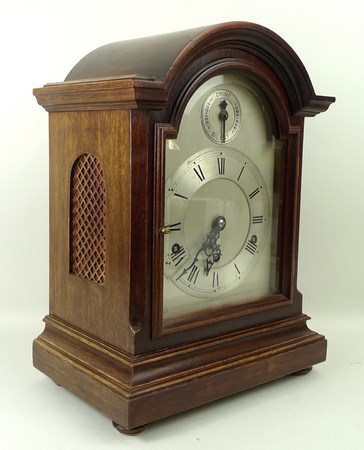 A bracket clock in a mahogany case with Westminster chimes, silvered dial bearing Roman numerals,