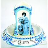 CALEY’S ASHTRAY/ MATCH-STRIKER. 4.75ins tall, 6ins across oval base, blue & white with lady at