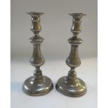 A pair of white metal ejector candlestic