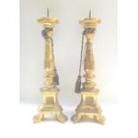 A pair of yellow/giltwood altar candlest