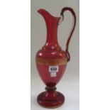 A Victorian cranberry glass ewer with a