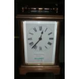 A brass cased carriage clock with white