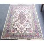 A Kerman rug, the ivory field with a sage and blue medallion, matching border and floral sprays,