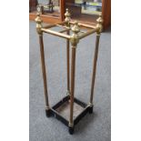 An Edwardian brass and cast iron four division stick stand of square section, with turned finials