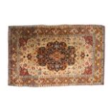 A Tehran rug, Persian, the beige field with a bold dark indigo medallion, madder spandrels, all