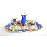 An English porcelain desk stand, circa 1840, with loop handle and shaped foliate encrusted body