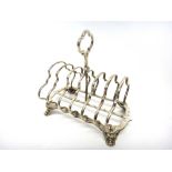 A Victorian silver seven bar toastrack, of shaped rectangular form, raised on four scroll pierced