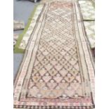 A kelim runner, Persian, the walnut field with an allover plant design, three borders, 360cm x