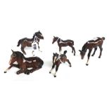 A Beswick Shetland pony and four Beswick brown gloss foals, black printed marks, the tallest 9.5cm