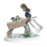 A Lladro figure modelled as a young girl pushing a wheelbarrow full of flowers (20.