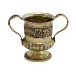 A silver gilt twin handled cup of campana form, the body boldly decorated with a band of fruiting